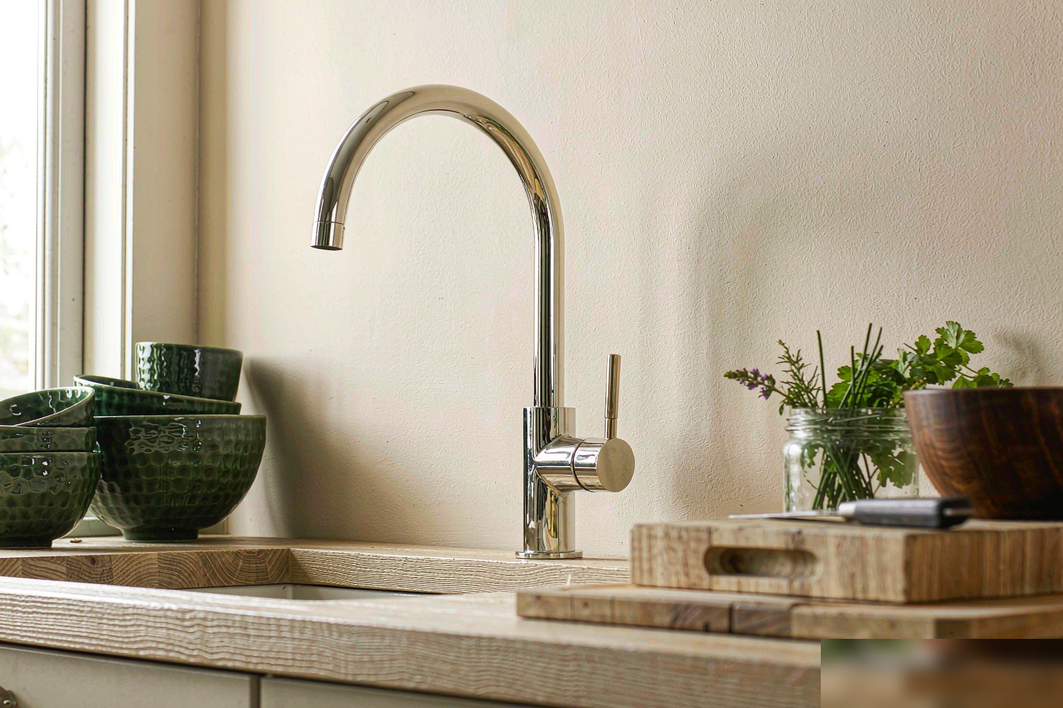 Single brass kitchen faucet on butcher block